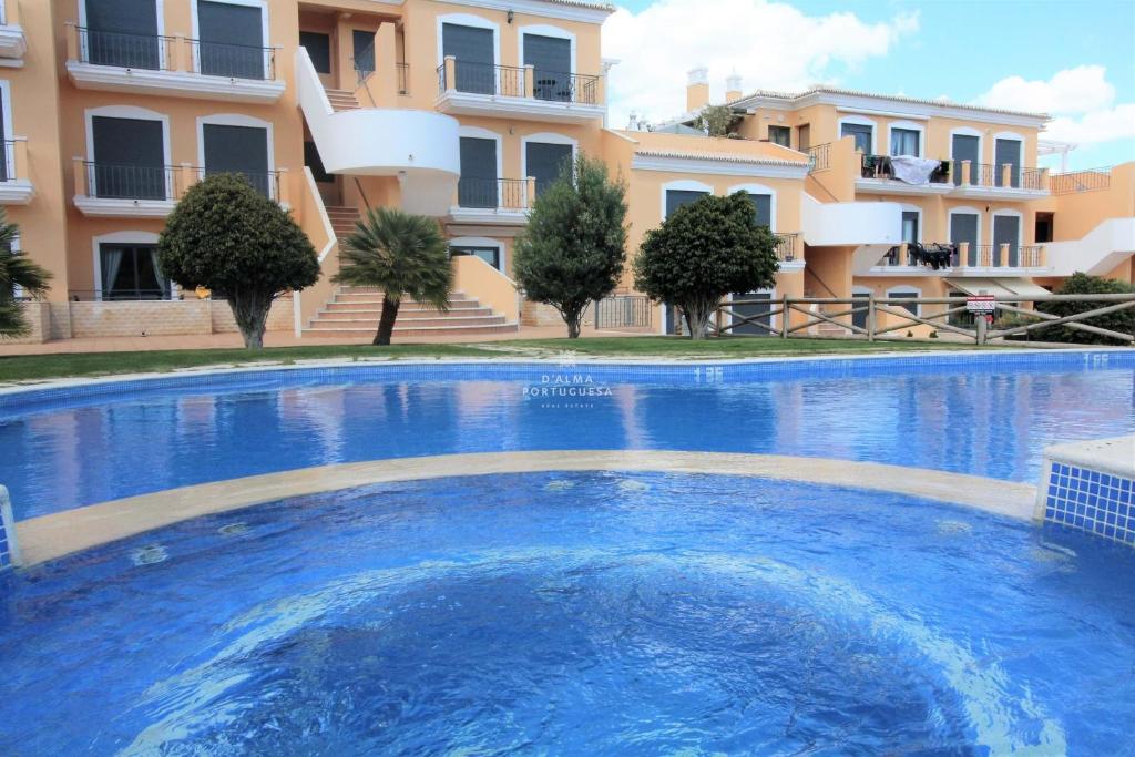 a large blue swimming pool in front of a building at Apartment Garcas Lounge - By Dalma Portuguesa in Albufeira