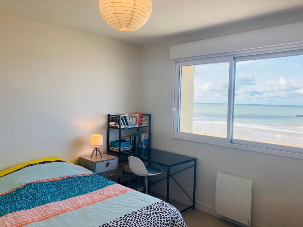 une chambre avec un lit, un bureau et une fenêtre dans l'établissement 180° vue océan, T3 marin haut de gamme, à Saint-Jean-de-Monts