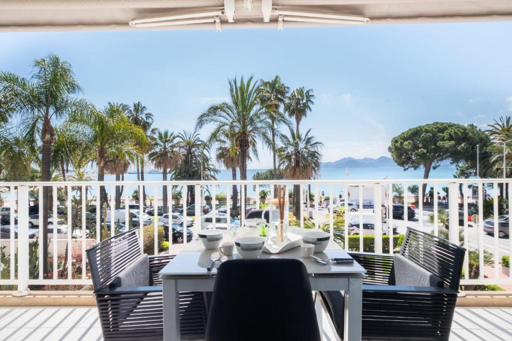 a table on a balcony with a view of the ocean at SERRENDY Sea view terrace upscale property in Cannes