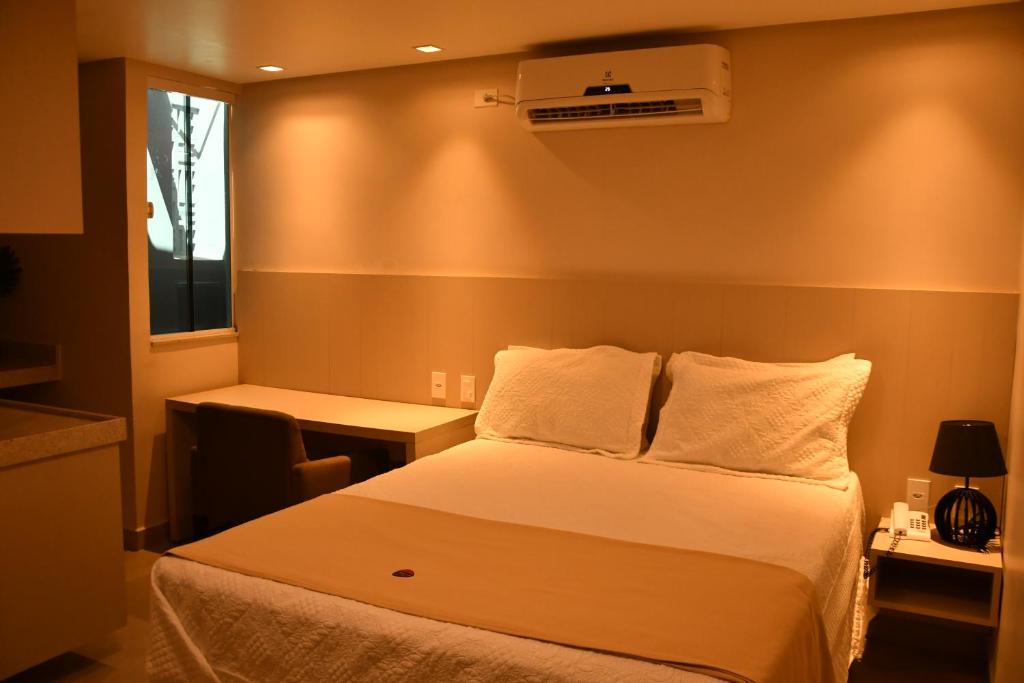 1 dormitorio con 1 cama, escritorio y ventana en Troodon Park Hotel, en Sousa