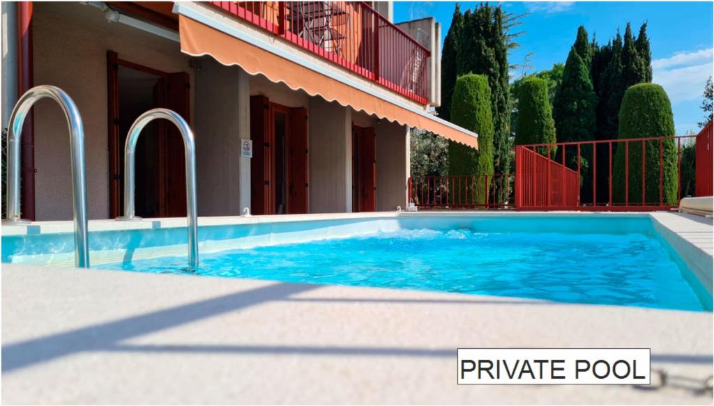 a swimming pool in front of a house at Arcave Luxury Apartment in Sirmione