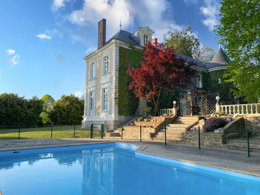 a house with a swimming pool in front of it at Château de Montaupin in Oizé