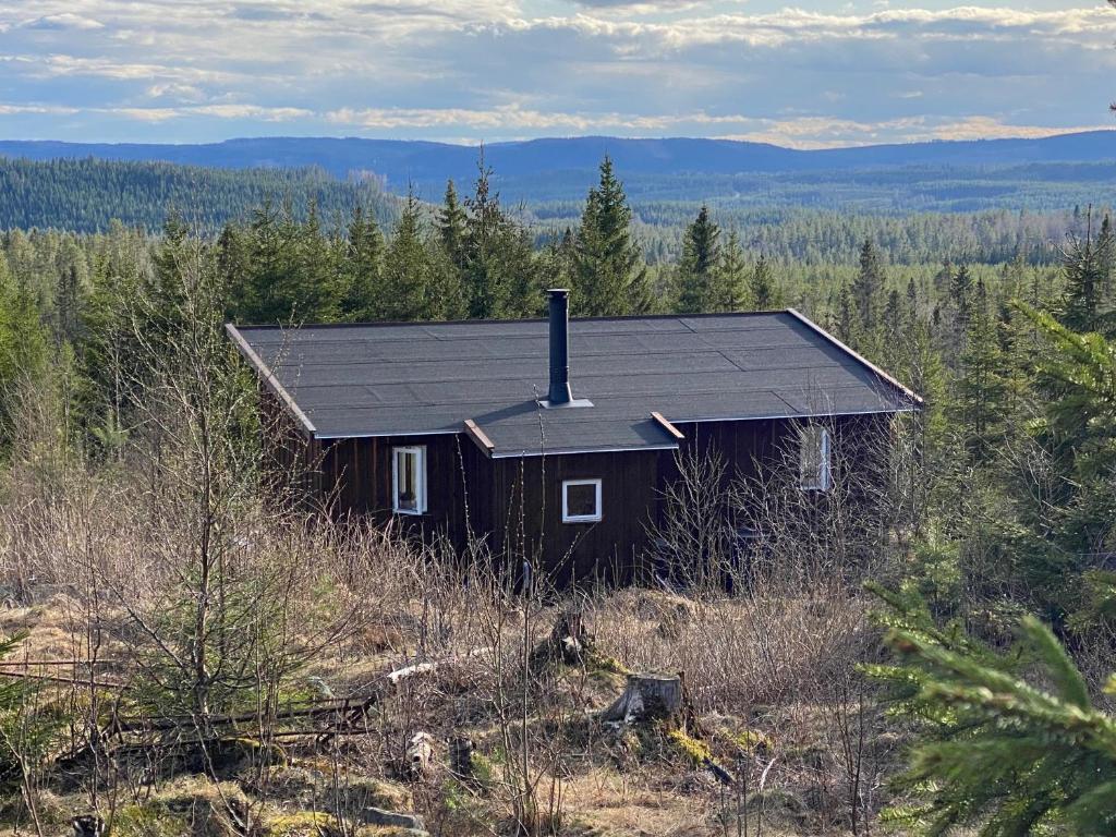 a small house sitting on top of a hill at Cozy forest cabin with amazing mountain view in Torsby