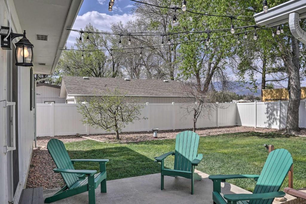 キャノン・シティにあるPet-Friendly Canon City Home with Fenced Yard!の庭付きのパティオ(緑の椅子2脚付)
