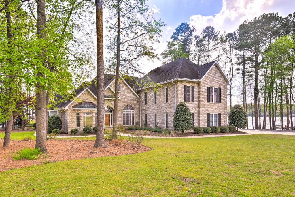 una casa en el bosque con un gran patio en Grand Mt Gilead Villa on Lake Tillery with Dock, en Mount Gilead