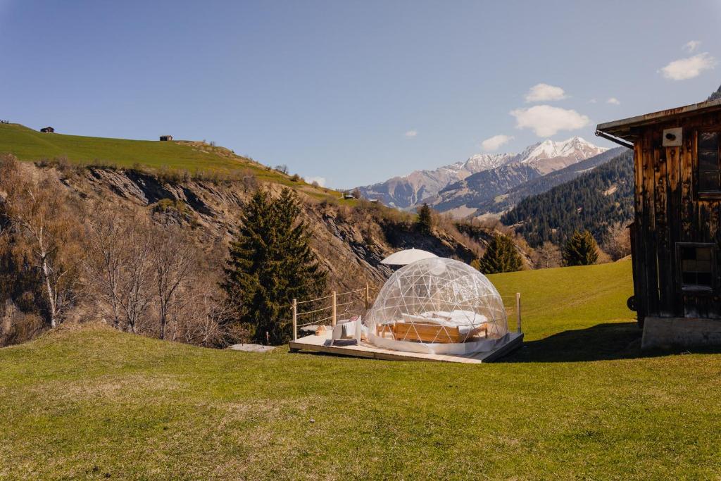 Lumbrein的住宿－Bubble-Suite mit wunderschönem Blick，山丘上一个玻璃 ⁇ 顶,山底下有山