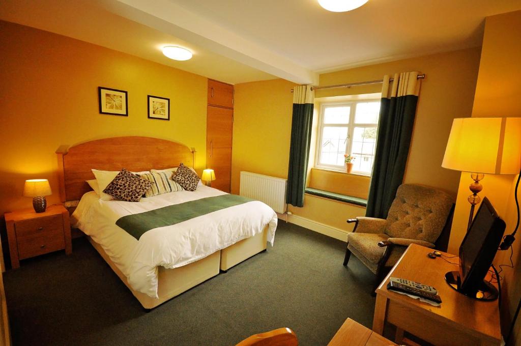 a bedroom with a bed and a desk and a chair at The Castle Hotel in Talgarth