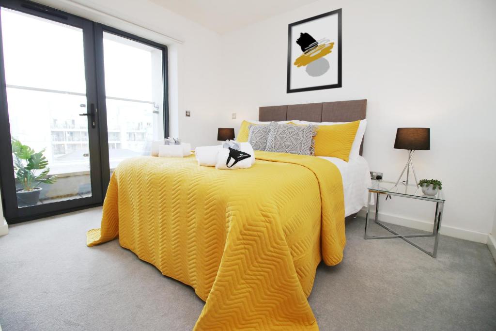 sypialnia z żółtym łóżkiem i żółtym kocem w obiekcie Dray Court - Luxury 2 Bedroom Apartment w Cardiff