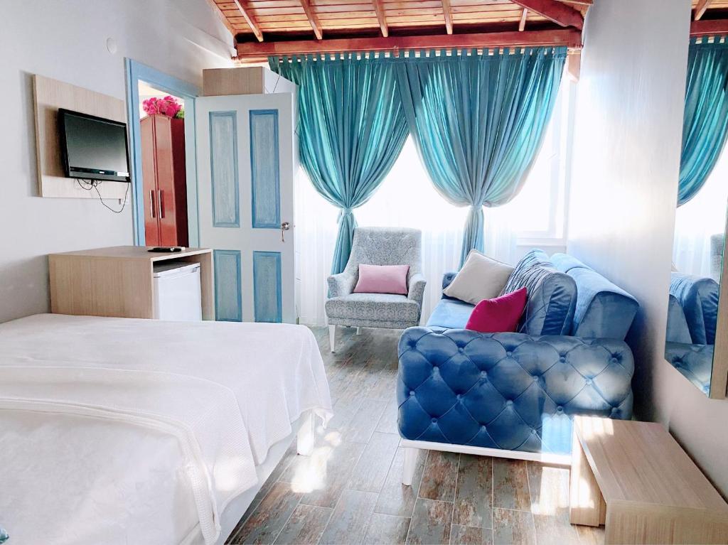 a bedroom with a bed and a couch and a chair at Çeşme Flowers Hotel in Ildır