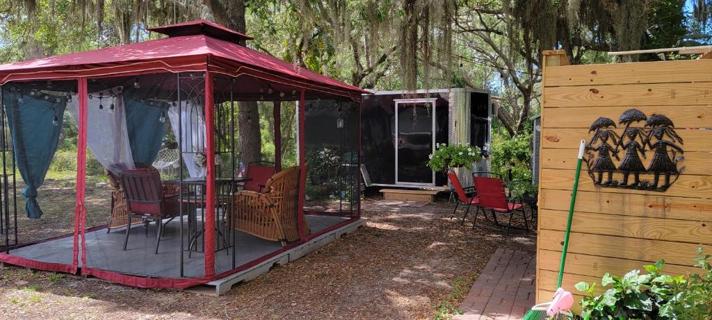 a gazebo with chairs and a table in a yard at Sleep Birds glamping trailer 5min to the beach in Nokomis