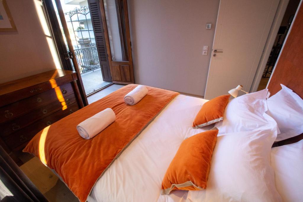 a large bed with orange and white pillows on it at Villa Saint Enogat in Aix-les-Bains