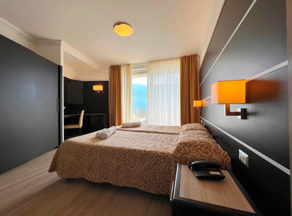 トレモージネ・スル・ガルダにあるVillage Bazzanega - Montagnoli Groupのベッドとテーブルが備わるホテルルームです。