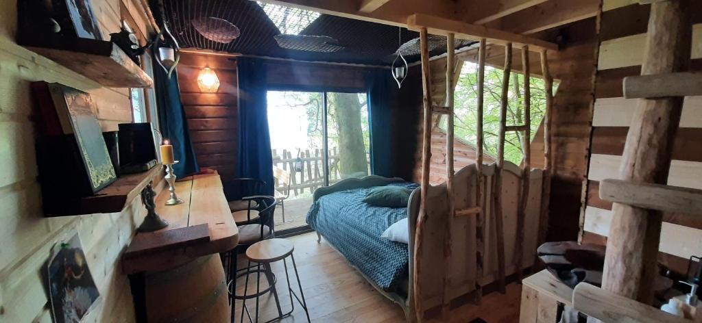 um quarto com uma cama numa casa na árvore em Cabane du Druide Domaine de Fangorn em Glux