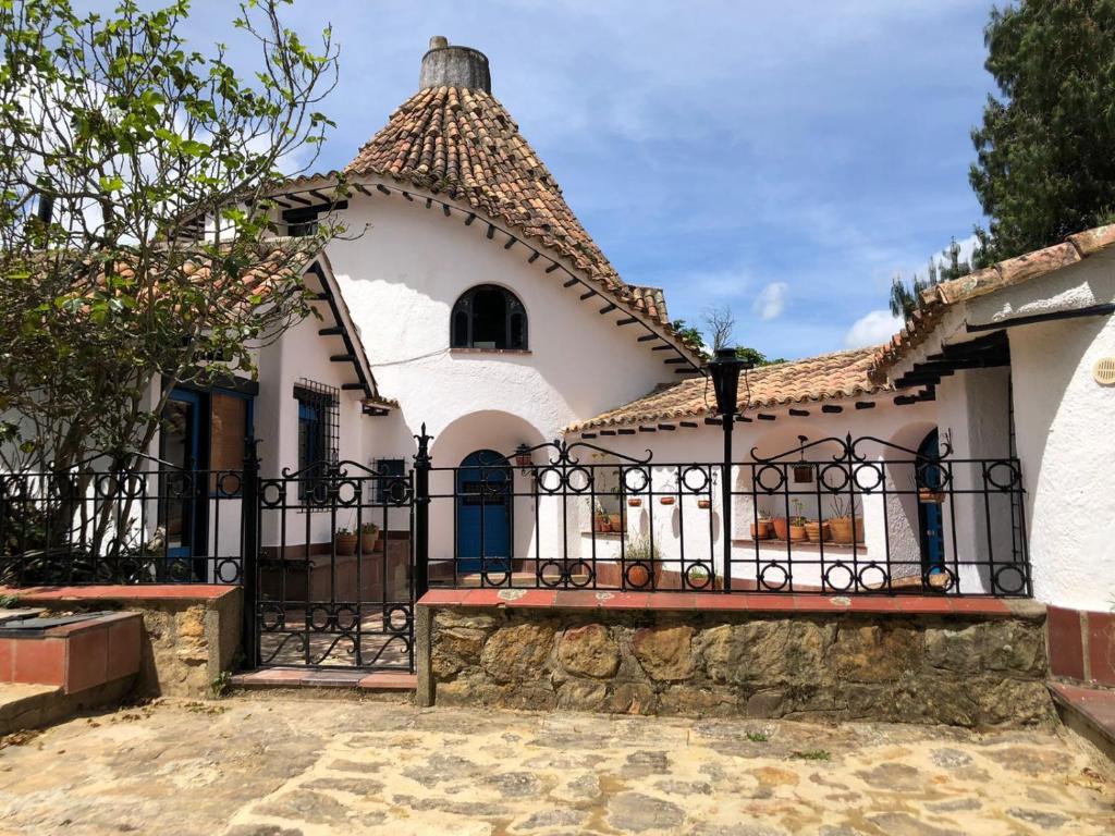 a large white house with a black fence at La Ronda in Guatavita