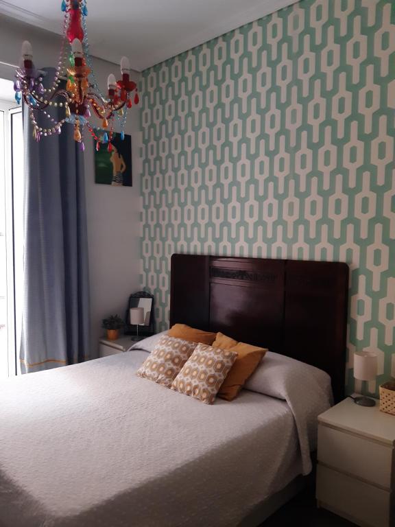 1 dormitorio con 1 cama con lámpara de araña encima en Flo Studios, en Nápoles