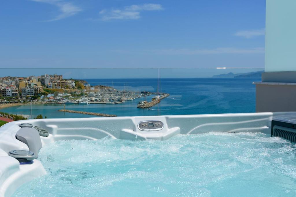 a jacuzzi tub with a view of the water at Angelique Luxury apartment in Agios Nikolaos