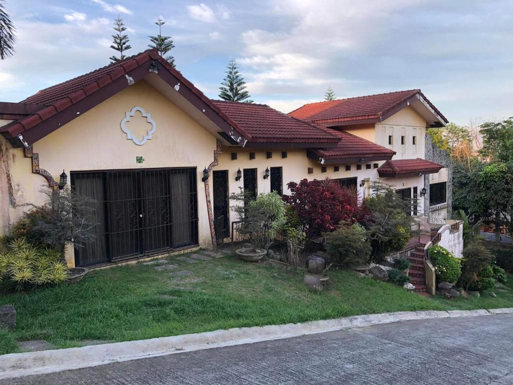 a house with a gate in front of a yard at Tagaytay BNR Guesthouse 4BR With Balcony 12-14 Guest in Tagaytay