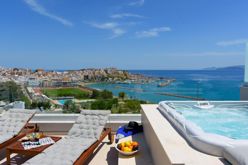 uma varanda com piscina e vista para a cidade em Angelique Luxury apartment em Agios Nikolaos