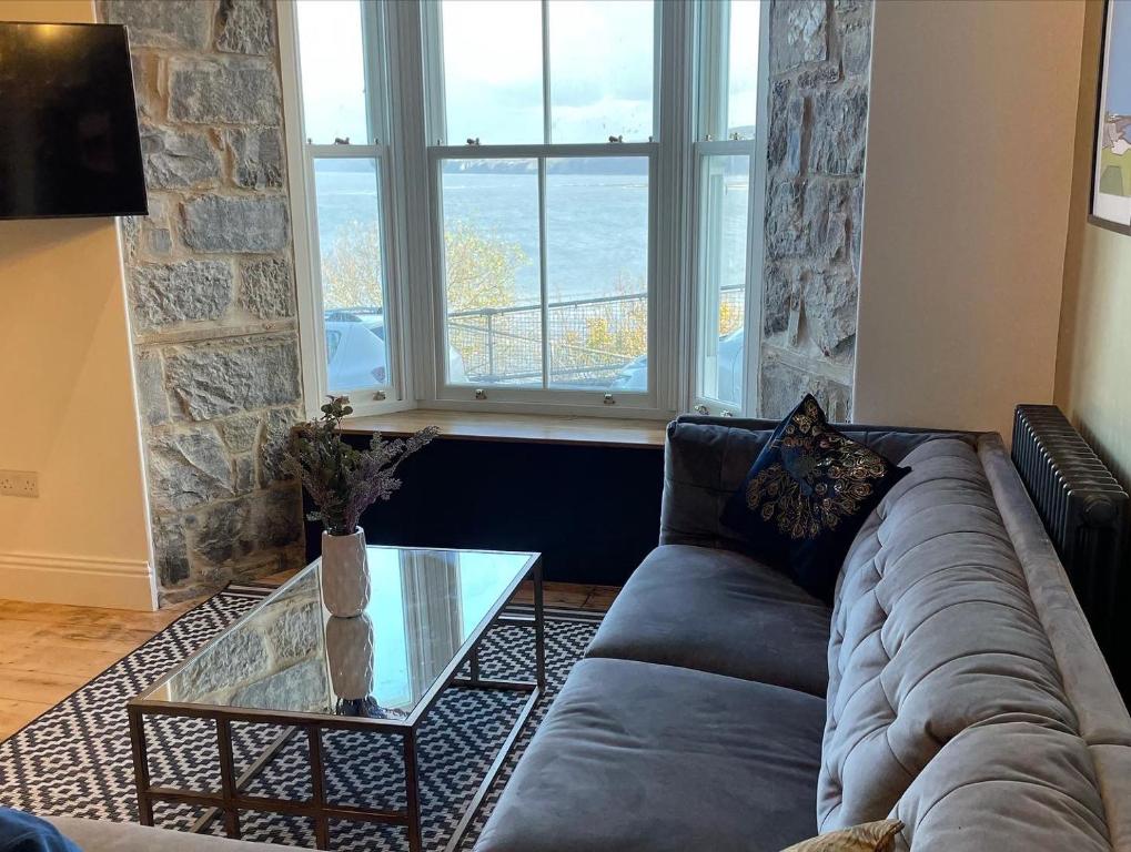 a living room with a couch and a glass table at Swn Y Don New Quay in New Quay