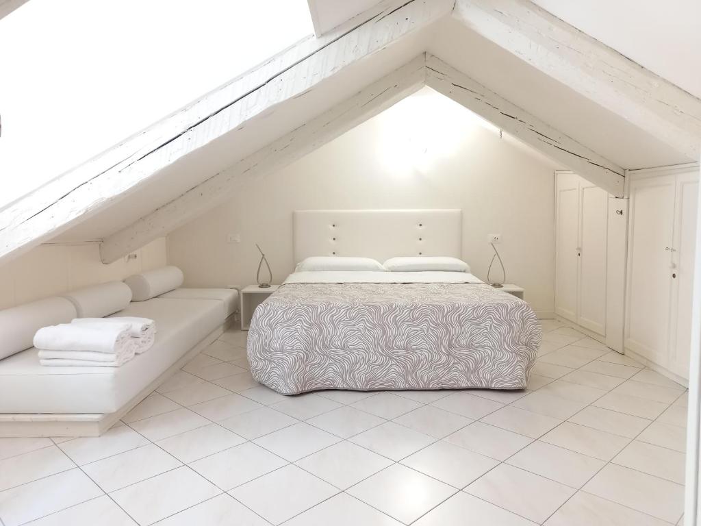 een witte slaapkamer met een bed en een bank bij Casanova Apartment San Marco in Venetië