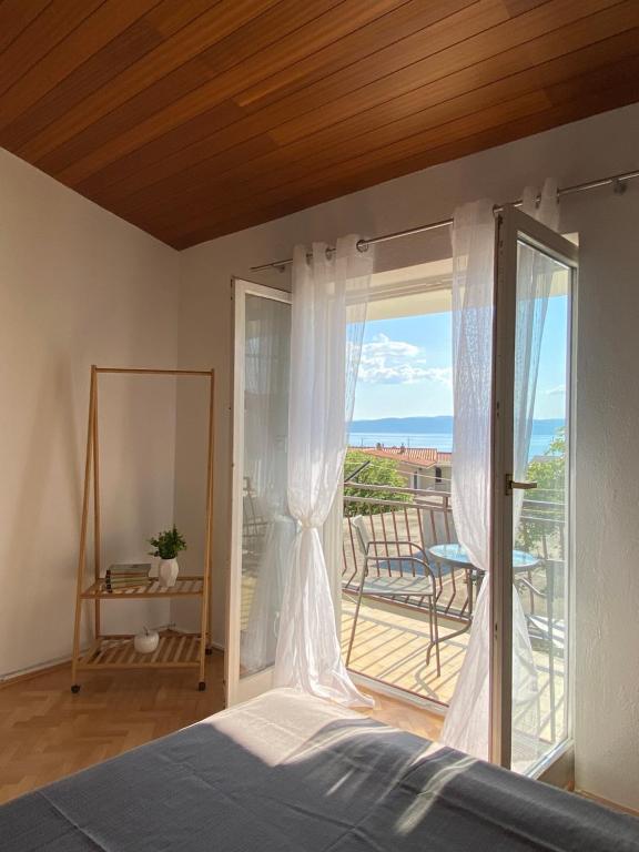 a bedroom with a bed and a balcony at Studio apartman More in Baška Voda