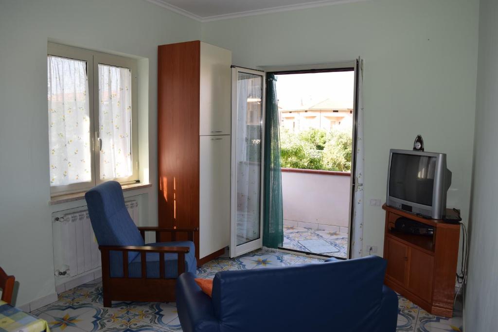 a living room with a tv and a blue chair at Mare e Terme a Guardia Piemontese in Guardia Piemontese Terme
