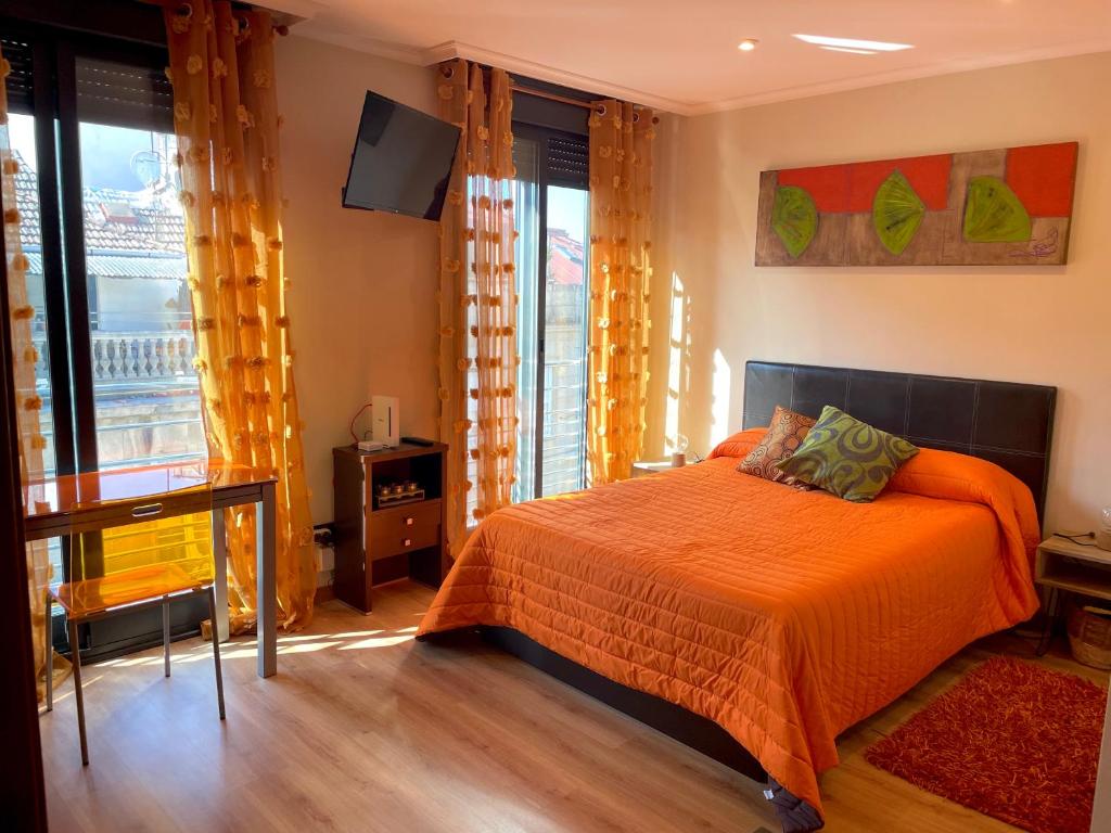 a bedroom with a bed with orange sheets and windows at Ronda De Don Bosco52 By Vigovacaciones in Vigo