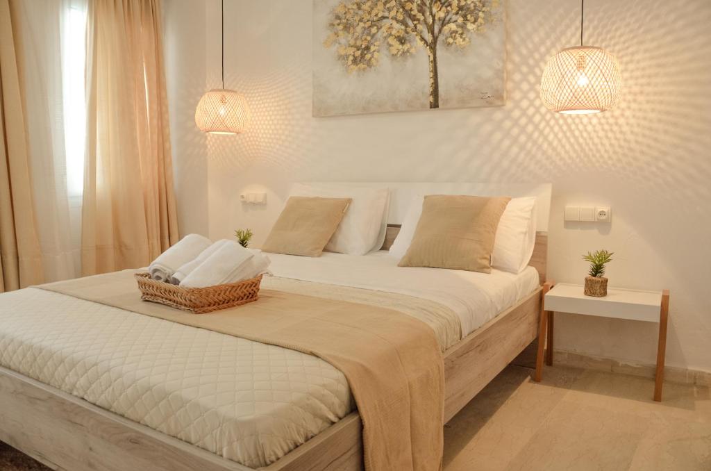 een slaapkamer met een groot bed met witte lakens en kussens bij Vel Boutique Suites in Agia Galini