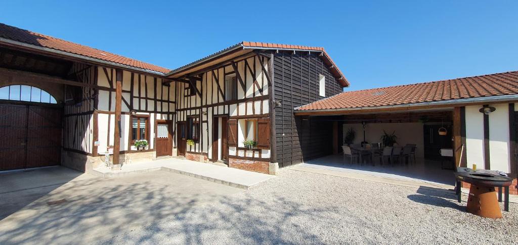 einen Außenblick auf ein Haus mit einer Terrasse in der Unterkunft La pinsonnière in Heiltz-le-Hutier