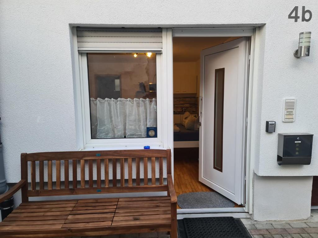 un banc en bois assis devant une fenêtre dans l'établissement Ferienwohnung Kramer, à Kippenheim