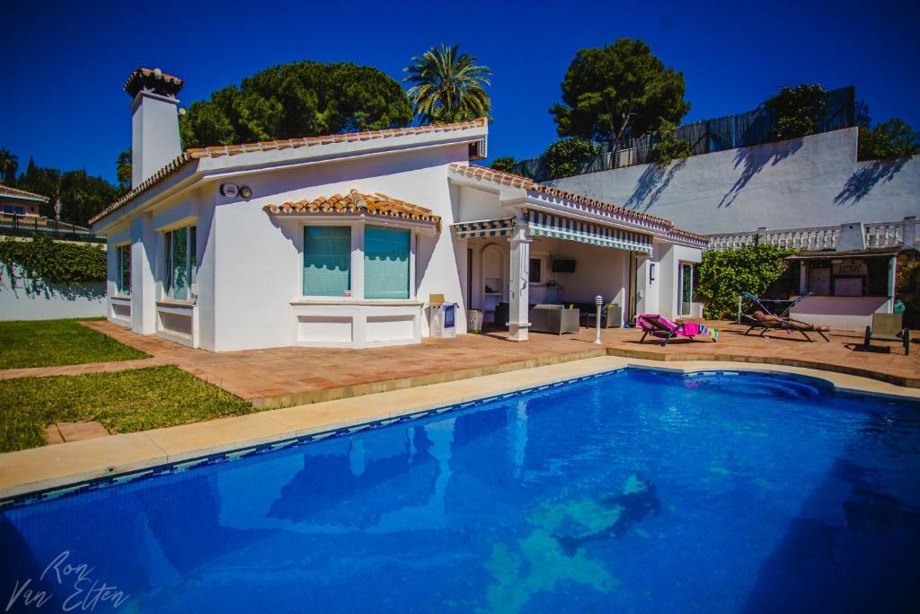 une villa avec une piscine en face d'une maison dans l'établissement Villa Estrella Del Mar, à Marbella
