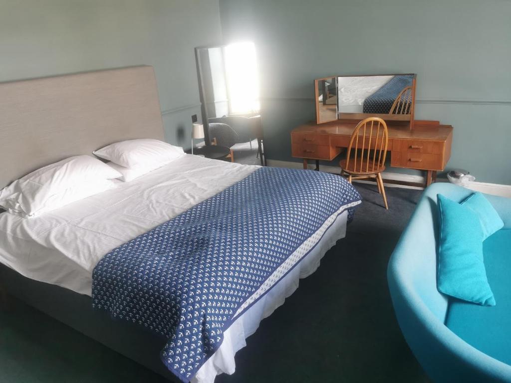 1 dormitorio con cama, escritorio y silla en The Townhouse, en Falmouth