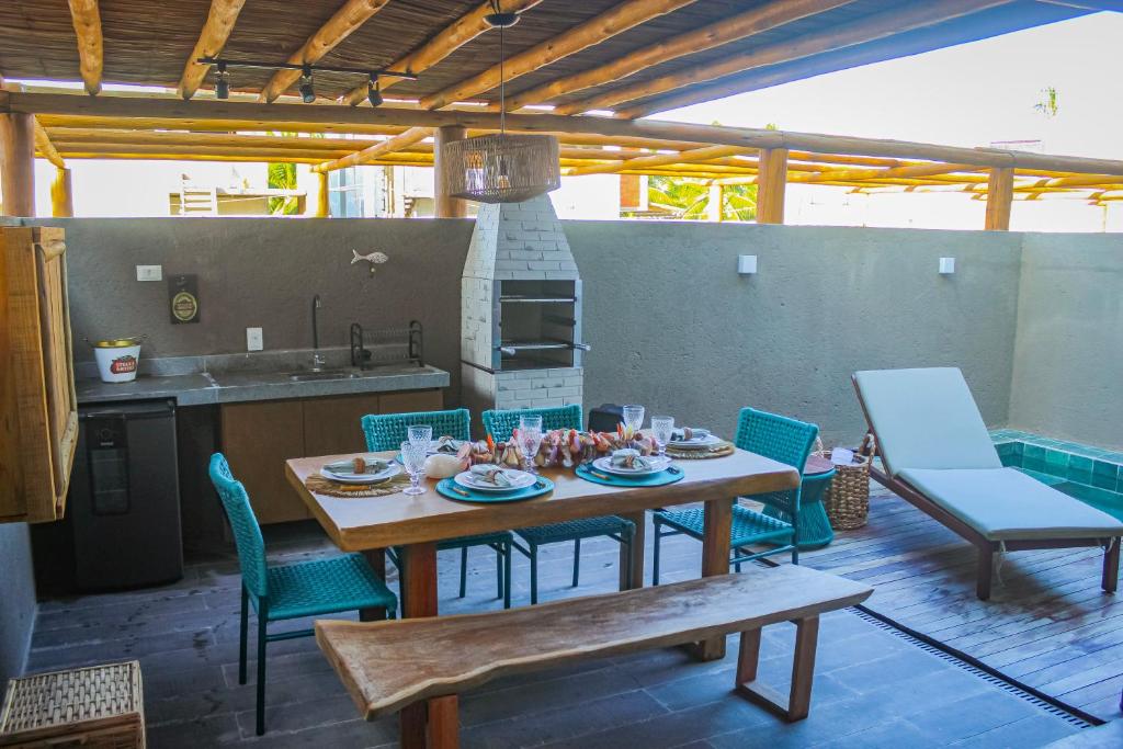 a table and chairs on a patio with a kitchen at Casa Riacho in São Miguel dos Milagres