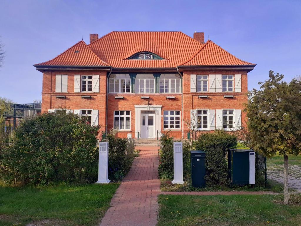 Lischow的住宿－Haus 2 Linden，一座带橙色屋顶的大型砖屋