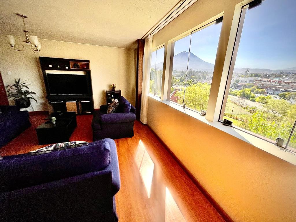 a living room with two purple chairs and a large window at Exclusivo y amplio- Great View in Arequipa