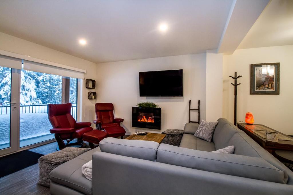 a living room with a couch and a fireplace at Magog Condo by Revelstoke Vacations in Revelstoke