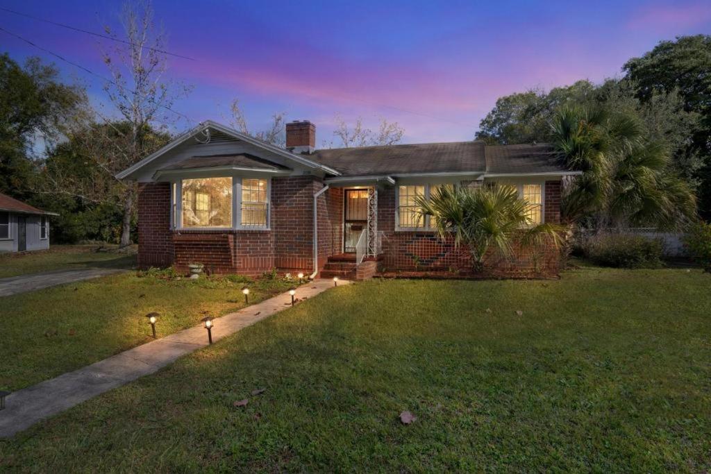 a brick house with lights in the yard at Comfy pet friendly home in Jacksonville mins to downtown’s in Jacksonville