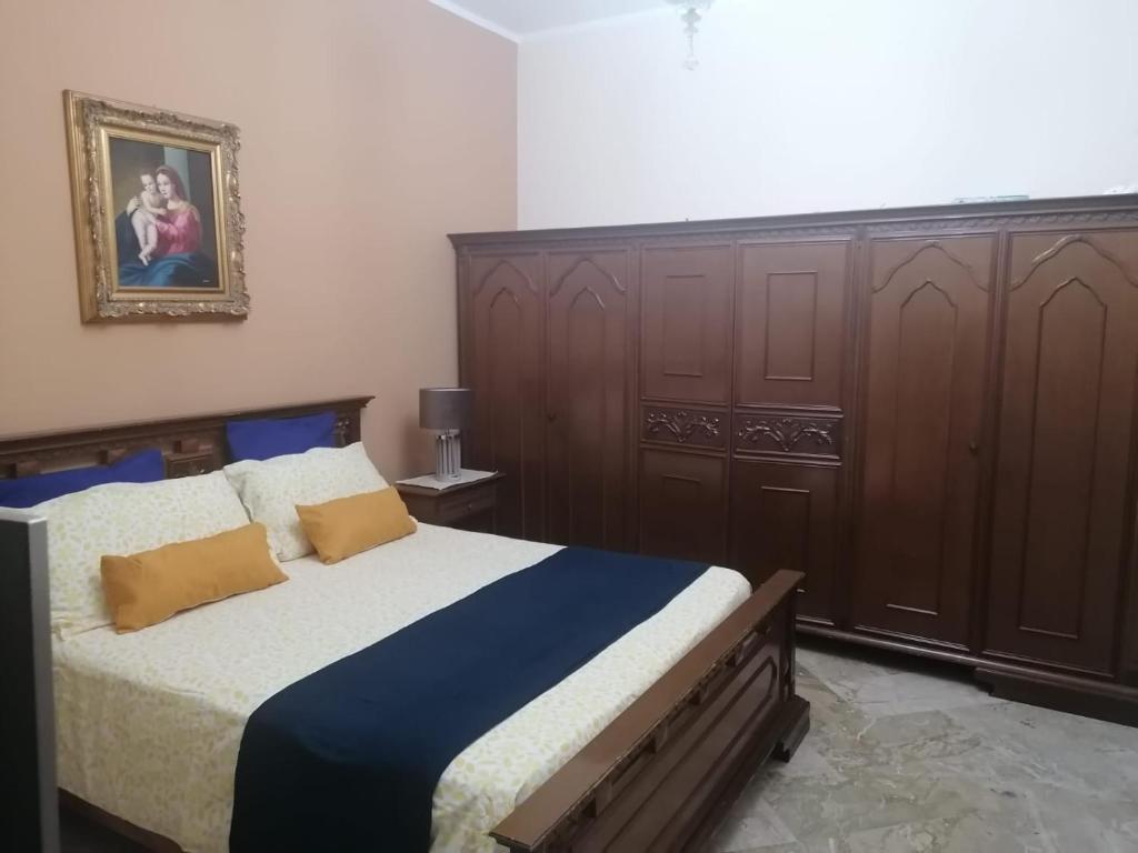 1 dormitorio con 1 cama grande y armarios de madera en Le stanze di Anna, en Capaci