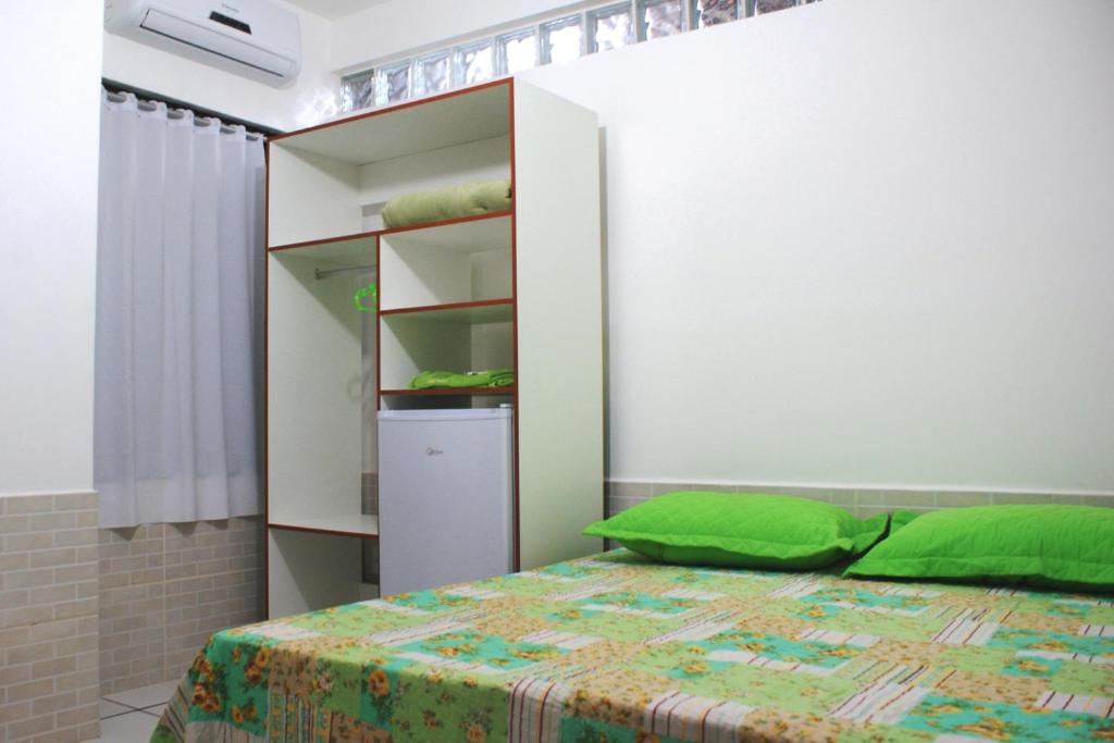 a bedroom with a bed and a book shelf at Pousada Bem Brasil in Macaé