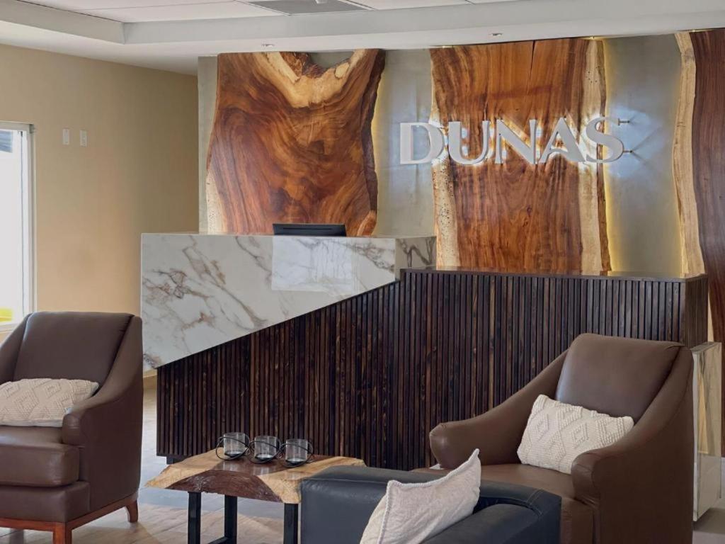 een woonkamer met 2 stoelen, een bank en een tafel bij Hotel Dunas Near Consulate in Ciudad Juárez