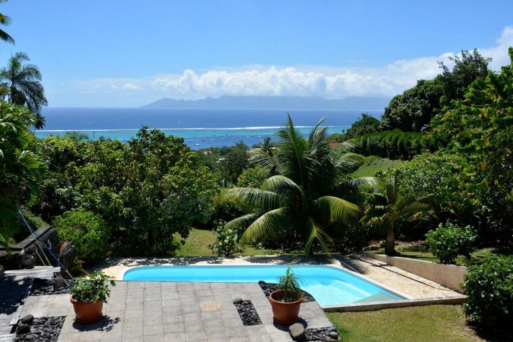 a swimming pool with a view of the ocean at Appartement Villa Taina piscine in Punaauia