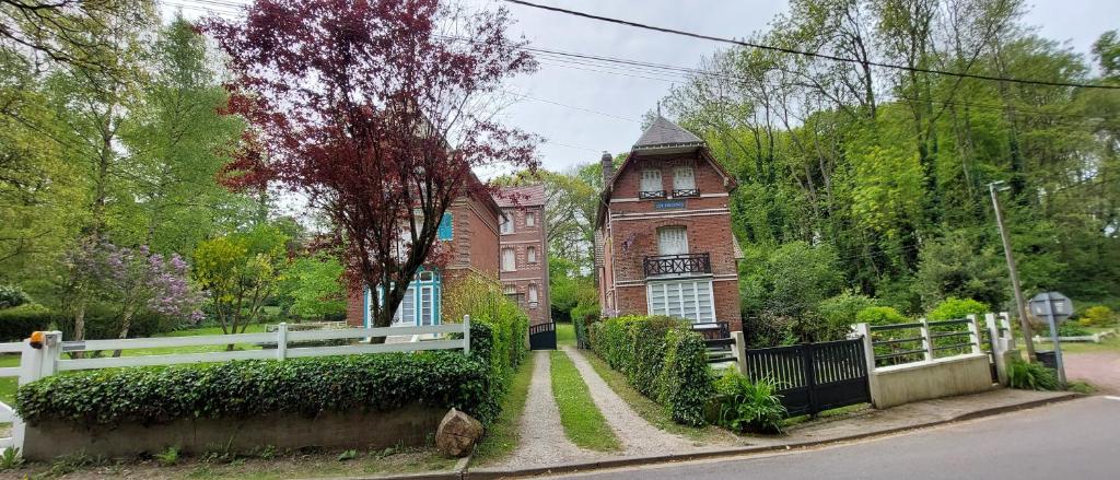 uma casa grande com uma cerca branca em frente em LE CISE EAU À bois em Le Bois de Cise