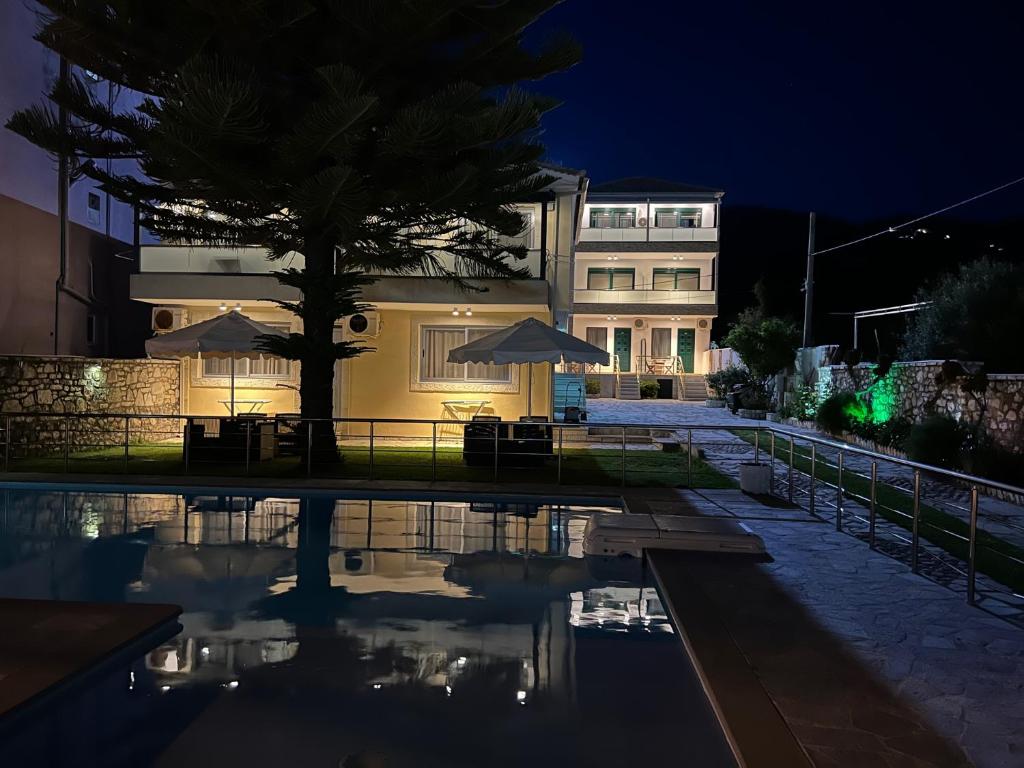 una casa con piscina por la noche en Dimitri Hotel, en Himare