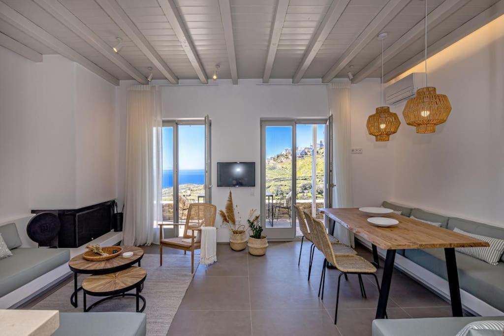 Villa Erato in Triantaros Tinos في Triandáros: غرفة معيشة مع طاولة وكراسي وأريكة