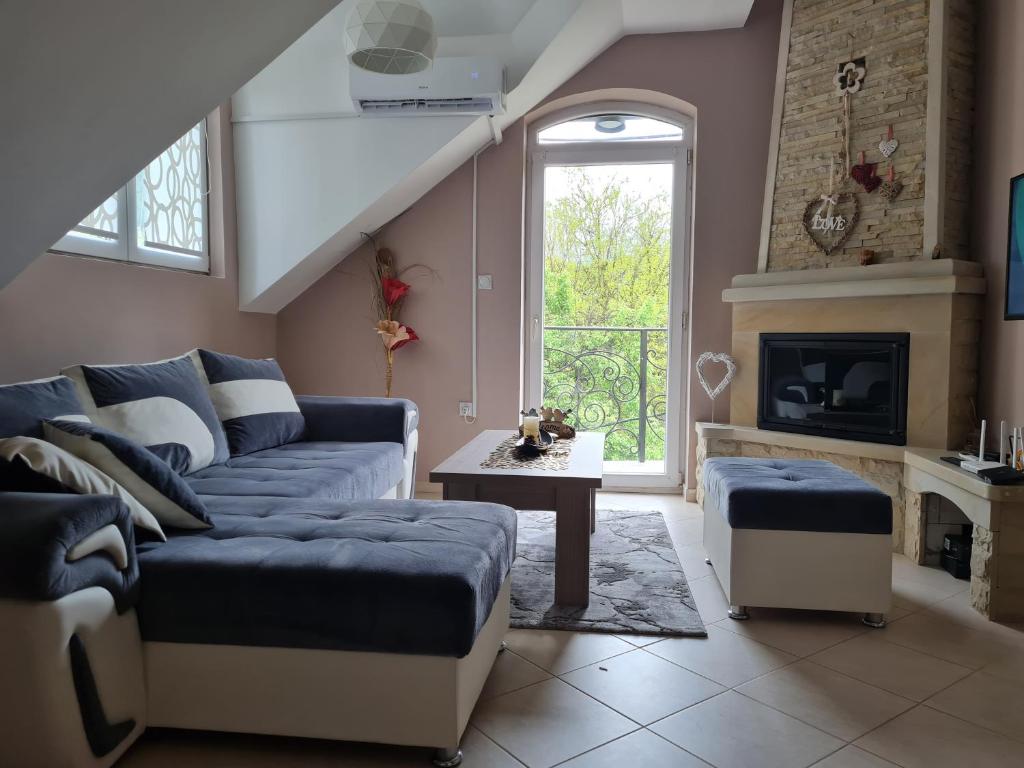 a living room with a blue couch and a fireplace at Apartman ALEX LUX in Vrnjačka Banja