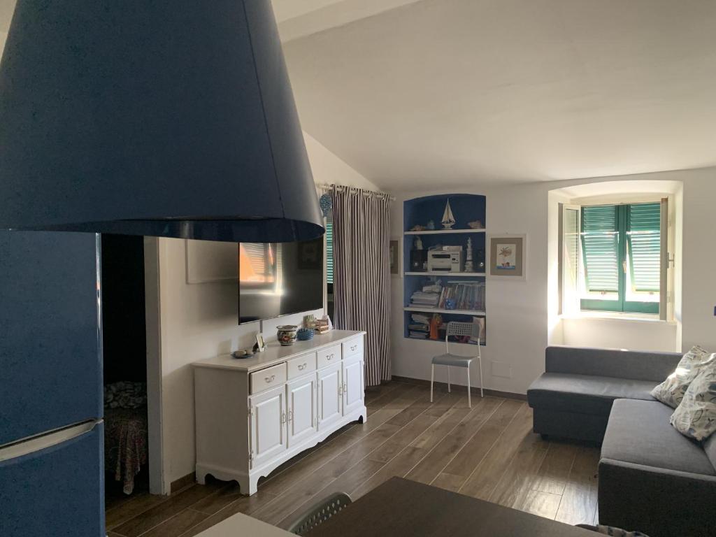 ein Wohnzimmer mit einem Sofa und einem TV in der Unterkunft Appartamento La casa di Chiara in Porto Azzurro