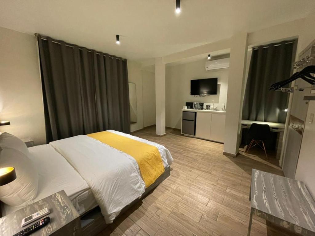 Habitación de hotel con cama y TV en Capital Suites en Chilpancingo 