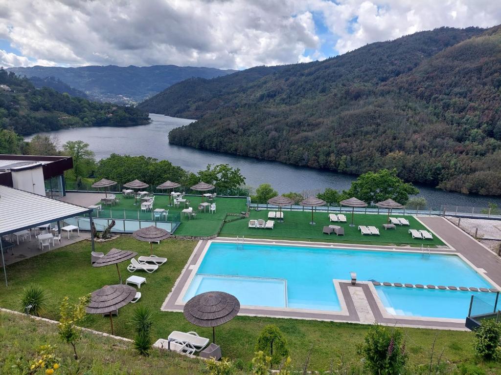 un complejo con piscina y río en Dobau casas en Vieira do Minho