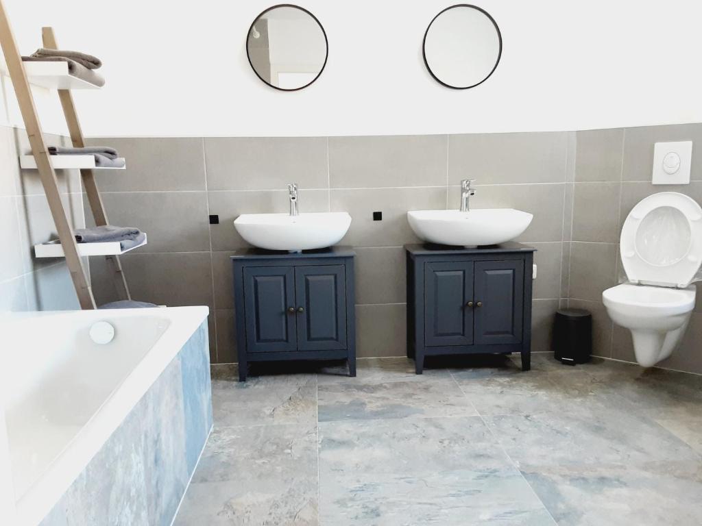 a bathroom with two sinks and a toilet at Nordunterkunft in Neumünster