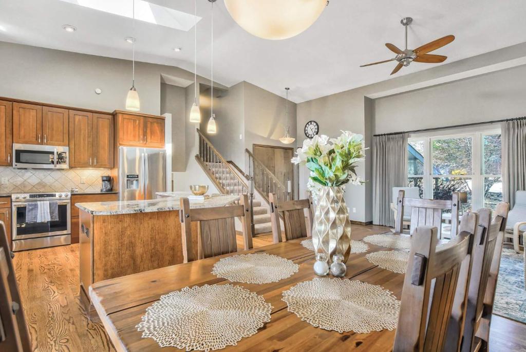 a kitchen and dining room with a vase of flowers on a table at NEW 5BR House with Peak Views in Colorado Springs in Colorado Springs